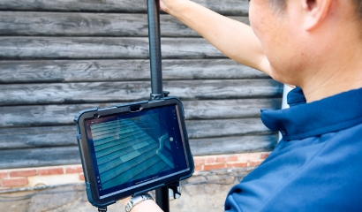 タブレットを持って高齢夫婦に説明している作業員