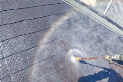 屋根を高圧洗浄機で洗浄している様子