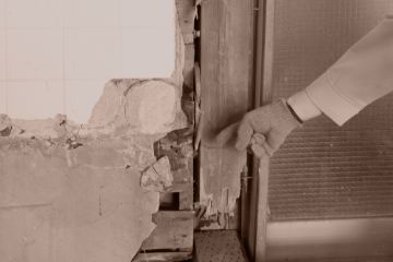 損傷した壁を指差ししている様子