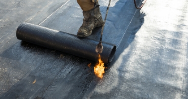 バーナーで加熱しながらアスファルト防水を施工する様子