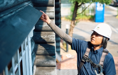 職人が天井裏を懐中電灯で点検している様子