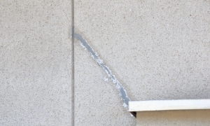 コンクリートの継ぎ目から白い液体が漏れ出ている様子